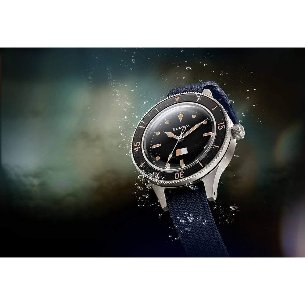 Uhr mit schwarzem Zifferblatt und blauem Armband unter Wasser mit Blasen