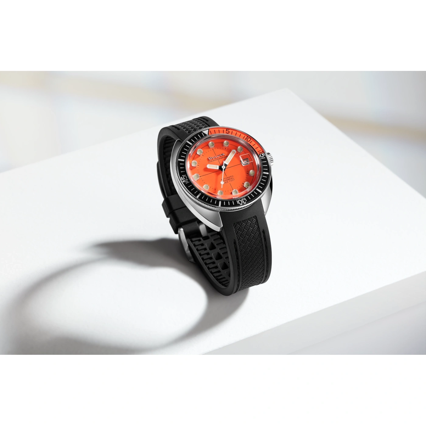 Uhr mit orangefarbenem Zifferblatt und schwarzem Armband auf weißem Hintergrund