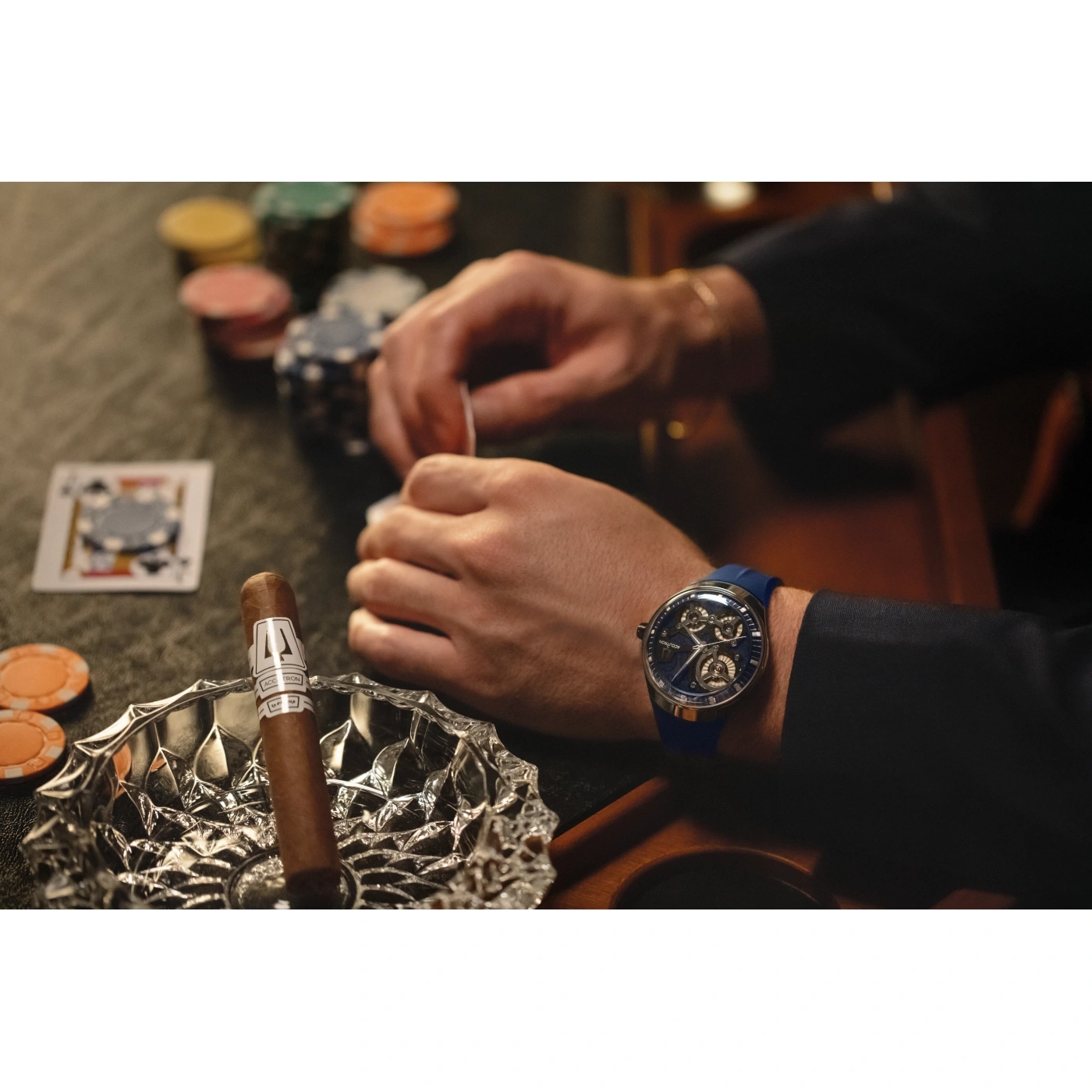 Mann spielt Poker mit Zigarre und Uhr. Spielkarten, Chips und Aschenbecher.