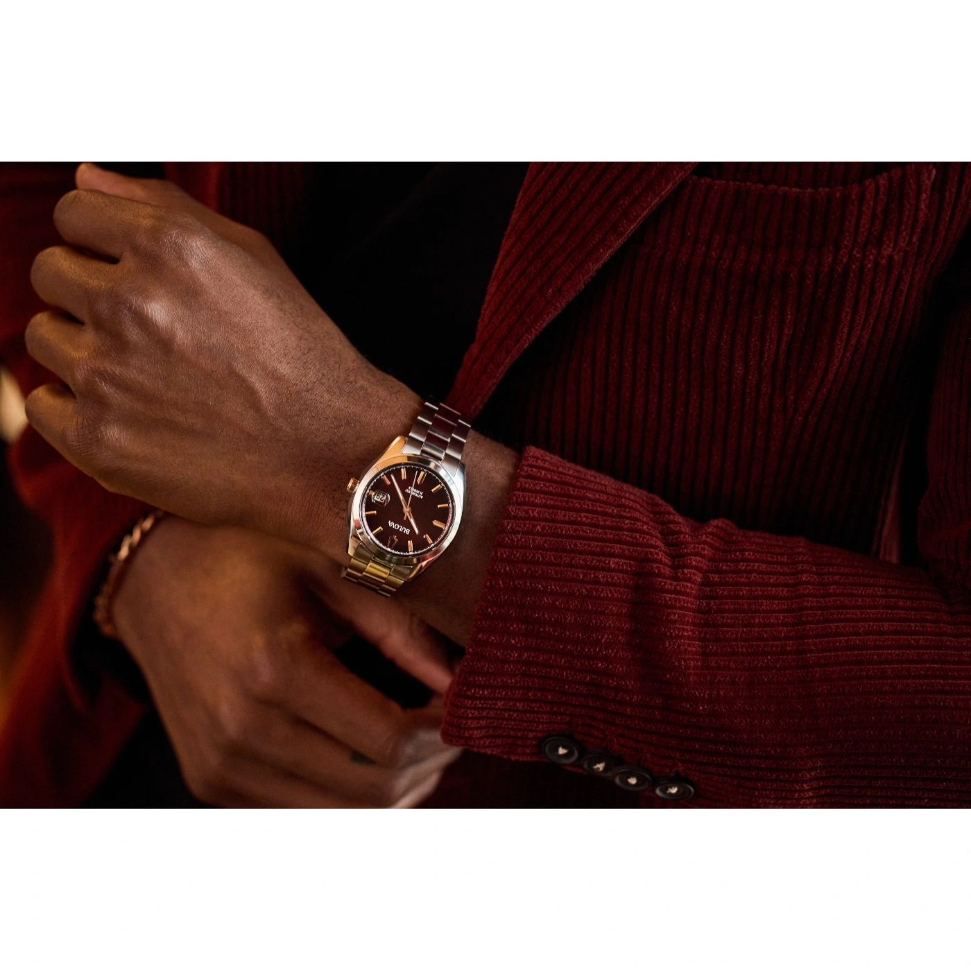 Mann trägt Uhr. Roter Anzug. Armbanduhr am Handgelenk. Nahaufnahme. Mode. Accessoire. Stil.