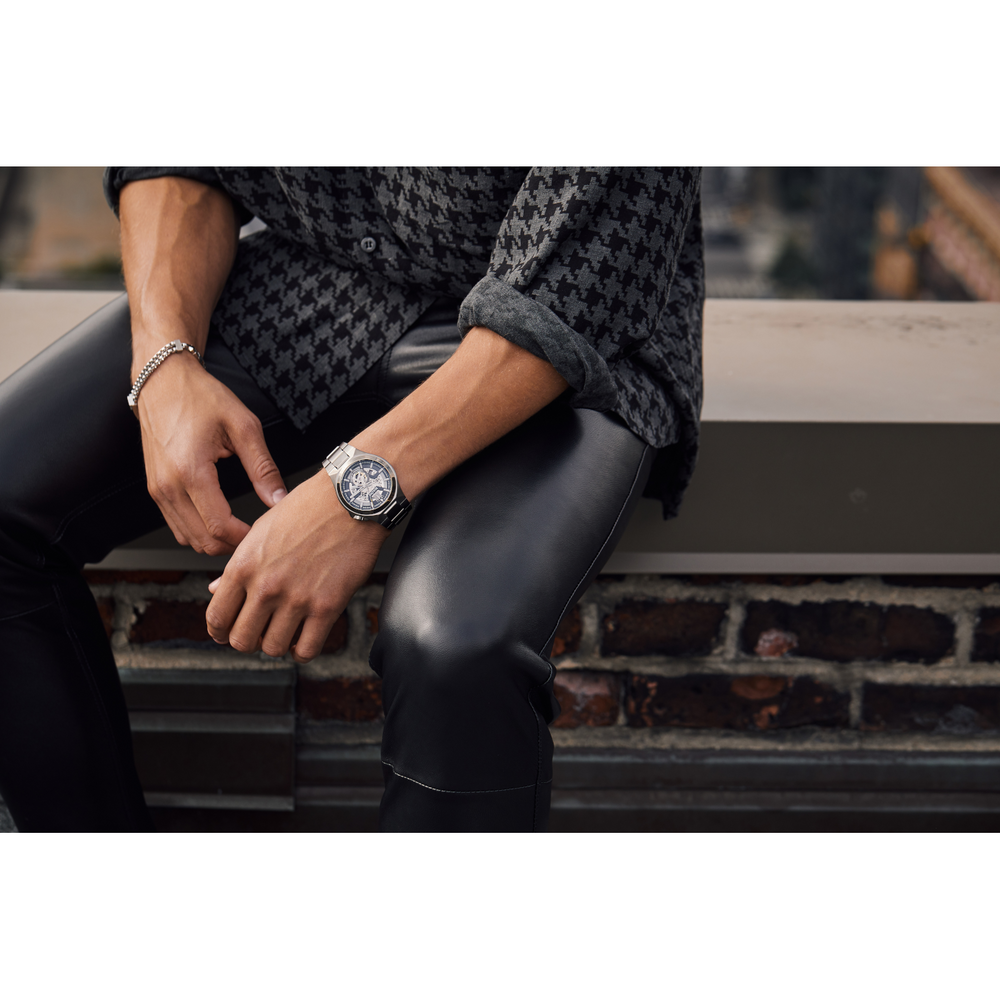 Mann mit Uhr und Armband, sitzt auf einer Mauer, Lederhose, Hemd
