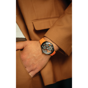 Mann mit Uhr und orangefarbenem Armband in brauner Jacke