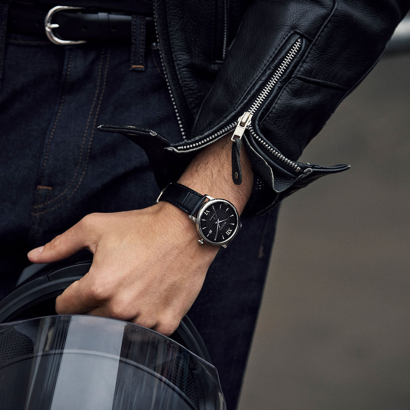 Mann mit Uhr und Lederjacke hält Helm. Nahaufnahme.