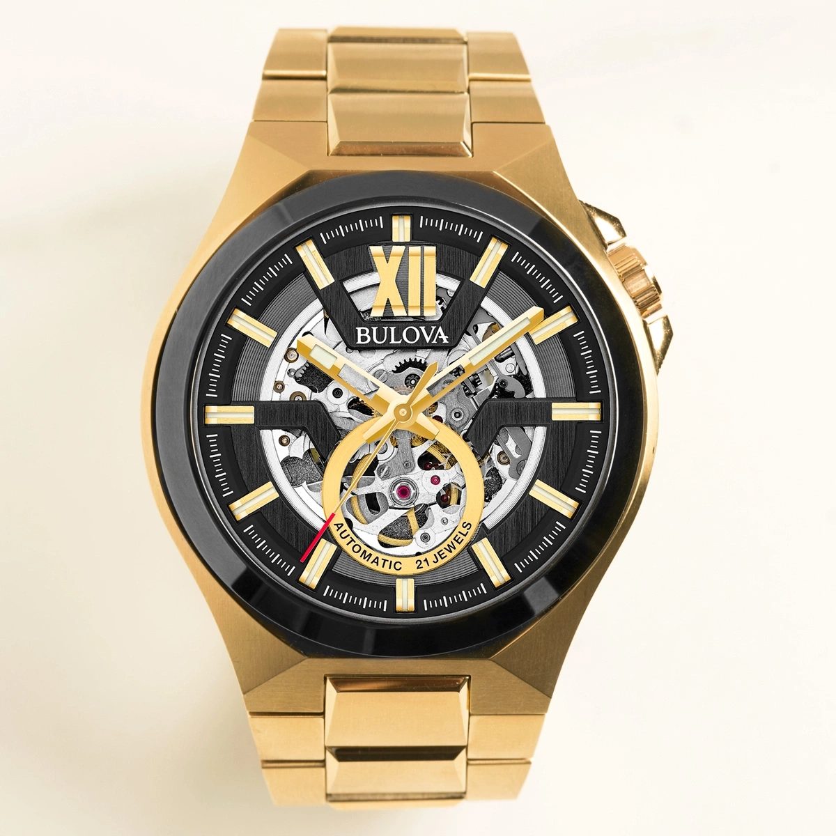 Goldene Bulova-Uhr mit schwarzem Zifferblatt und skelettiertem Design.