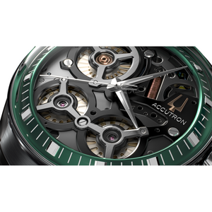 Nahaufnahme einer grünen Uhr mit freiliegenden Mechanismen und dem Wort Accutron.